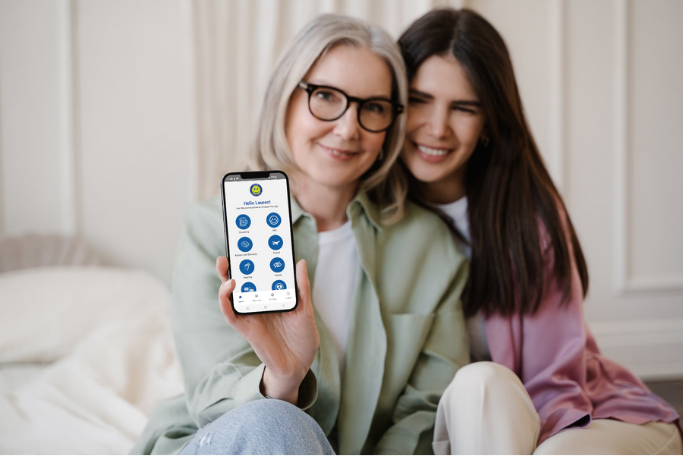 Two women showing the app on a mobile phone.